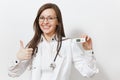 Smiling confident young doctor woman in medical gown with stethoscope glasses showing thumbs up, clinical electronic Royalty Free Stock Photo