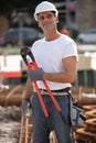 Smiling construction worker with boltcutters