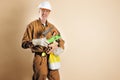 Smiling bricklayer holding tools and building materials brown  background Royalty Free Stock Photo