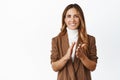 Smiling corporate woman clap hands, praising you, looking pleased and give applause to colleague, white background Royalty Free Stock Photo