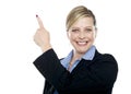 Smiling corporate woman pointing upwards