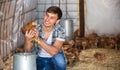 Smiling countryman holding brown chicken