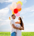 Smiling couple with air balloons outdoors Royalty Free Stock Photo