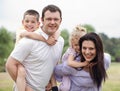 Smiling couple carrying kids on their back Royalty Free Stock Photo