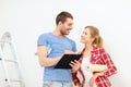 Smiling couple with clipboard and wallpaper roll