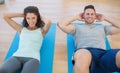 Smiling couple doing sit ups Royalty Free Stock Photo