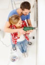 Smiling couple drilling hole in wall at home