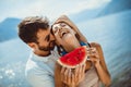 Smiling couple eating watermelon on the beach having fun Royalty Free Stock Photo