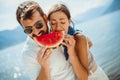 Smiling couple eating watermelon on the beach having fun Royalty Free Stock Photo