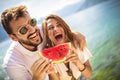 Smiling couple eating watermelon on the beach having fun Royalty Free Stock Photo