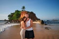 Smiling couple embraces on tropical beach at sunset. Happy man, woman enjoy summer vacation, sea. Romantic getaway Royalty Free Stock Photo