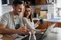 Smiling couple enjoying beautiful morning at home kitchen, starting to work from home in paj