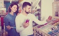 Smiling couple examining various paints in paint store Royalty Free Stock Photo