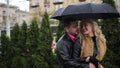 Smiling couple flirtation under the black umbrella when raining