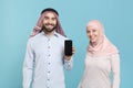 Smiling couple friends arabian muslim man wonam in keffiyeh kafiya ring igal agal hijab clothes isolated on blue