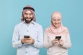 Smiling couple friends arabian muslim man wonam in keffiyeh kafiya ring igal agal hijab clothes isolated on blue