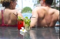 Smiling couple with glasses of alcohol cocktails near swimming pool Royalty Free Stock Photo