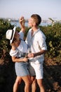 Smiling couple with glasses drinks wine in vineyaed