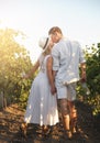 Smiling couple with glasses drinks wine in vineyard