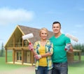 Smiling couple in gloves with paint rollers Royalty Free Stock Photo