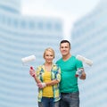 Smiling couple in gloves with paint rollers Royalty Free Stock Photo