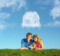 Smiling couple on grass and dream cloud house