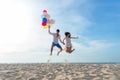 Smiling couple hand holding balloon and jumping together and congratulation graduation in Happy New year 2019 on the beach. Royalty Free Stock Photo