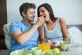 Smiling couple having breakfast on bed Royalty Free Stock Photo