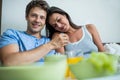 Smiling couple having breakfast on bed Royalty Free Stock Photo