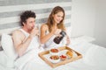 Smiling couple having breakfast on bed Royalty Free Stock Photo
