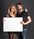 Smiling couple holding big blank white board Royalty Free Stock Photo