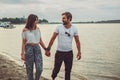 Smiling couple holding hands while walking on the beach Royalty Free Stock Photo