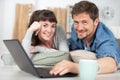 Smiling couple with laptop layed on cushions Royalty Free Stock Photo