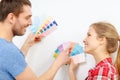 Smiling couple looking at color samples at home
