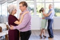 Smiling couple looking at each other while dancing slow dance in ballroom