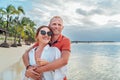 Smiling couple in love hugging on the sandy exotic beach while have evening walk by the Trou-aux-Biches seashore on Mauritius Royalty Free Stock Photo