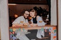 Smiling couple in love looking at photo on phone while drinking in bar on date Royalty Free Stock Photo