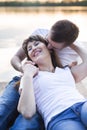 Smiling couple lying on the bridge on the shore of the lake at sunset Royalty Free Stock Photo