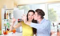 Smiling couple make a selfie in coffee bar