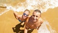 Smiling couple makes a selfie on the beach