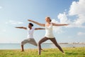 Smiling couple making yoga exercises outdoors Royalty Free Stock Photo