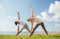 Smiling couple making yoga exercises outdoors Royalty Free Stock Photo