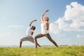 Smiling couple making yoga exercises outdoors Royalty Free Stock Photo