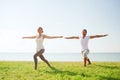 Smiling couple making yoga exercises outdoors Royalty Free Stock Photo