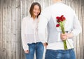 Smiling couple with man hiding roses in his back
