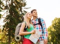 Smiling couple with map and backpack in nature Royalty Free Stock Photo