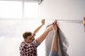 Smiling couple measuring wall using measure tape. Repair, building and home Royalty Free Stock Photo