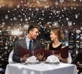 Smiling couple with menus at restaurant Royalty Free Stock Photo