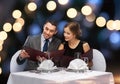 Smiling couple with menus at restaurant Royalty Free Stock Photo