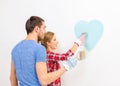 Smiling couple painting small heart on wall Royalty Free Stock Photo